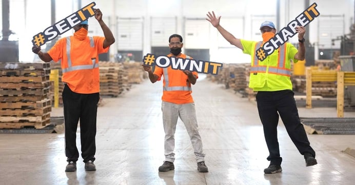 48forty employees holding hashtag signs that say see it, own it, share it