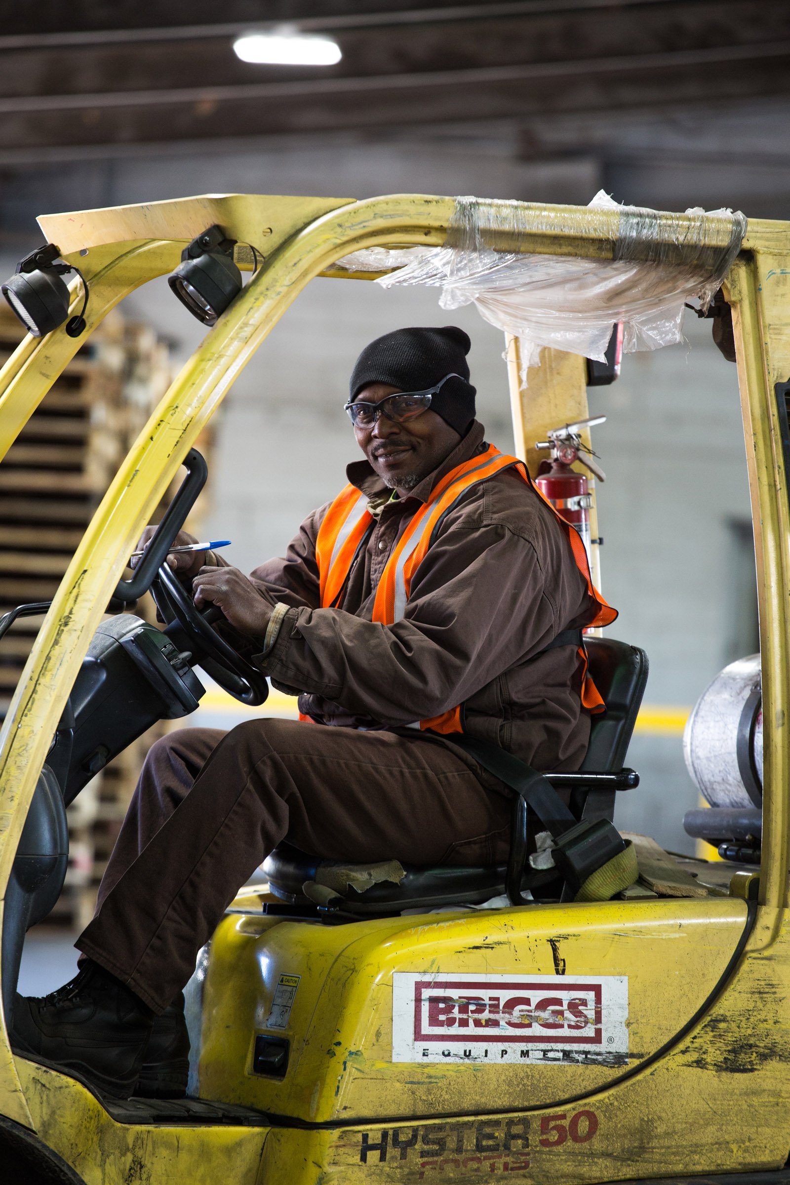 A smiling worker driving the forklift