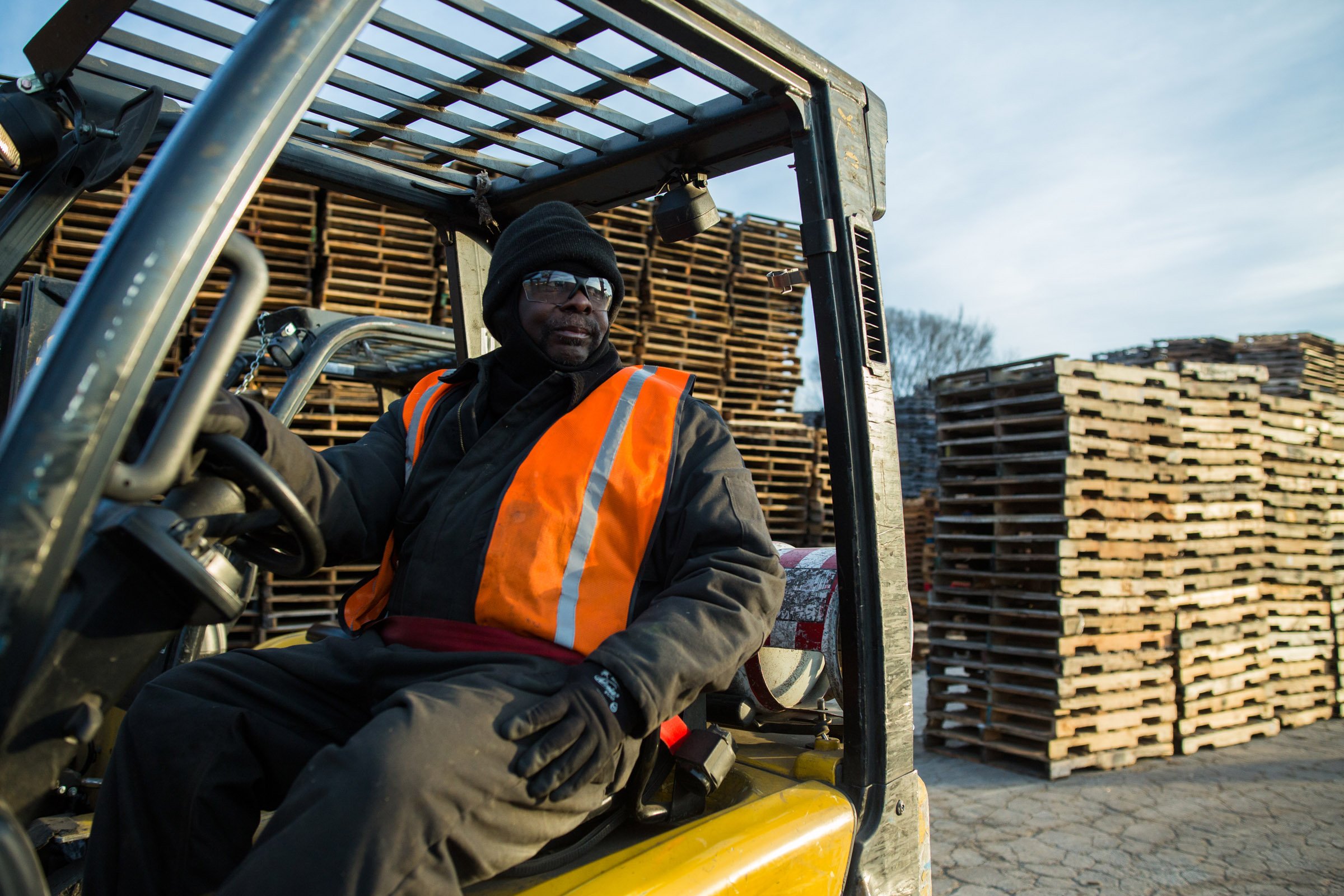 A man driving a forklift while looking off to his left